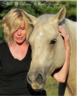 Kate with her arm around the head of her palomino mare.