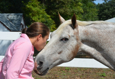 Toni kissing her appaloosa/Arabian horse on the nose after a healing with Ginger.